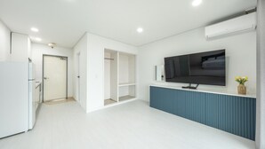 A modern kitchen with white cabinetry, a built-in oven, and a large window. - Taean Yeonpo Haibada Pension (Taean)