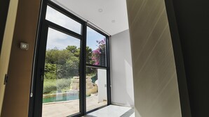 A modern room with a large sliding glass door leading to an outdoor pool area. - WELCS VILLA MODERNA 097 EMP con piscina (Llança)