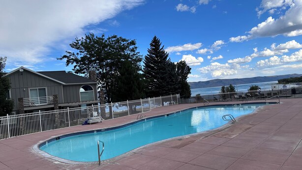 A swimming pool with a view of mountains and a body of water.