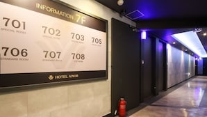 A hotel information board listing room numbers and types, including special and standard rooms, along with a fire extinguisher on the floor. - AmorHotelgimhae (Gimhae)