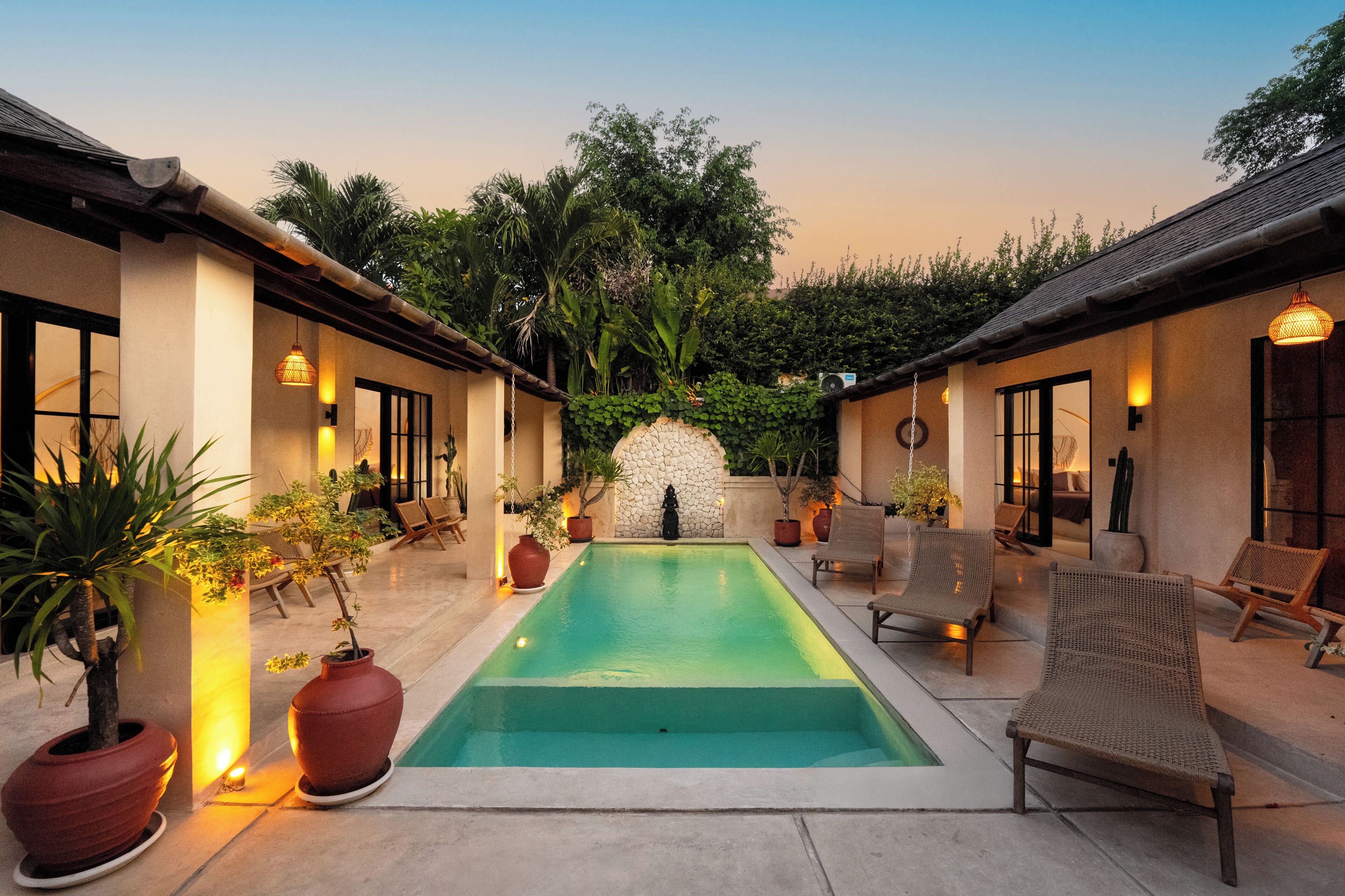 A pool area with lounge chairs and potted plants.