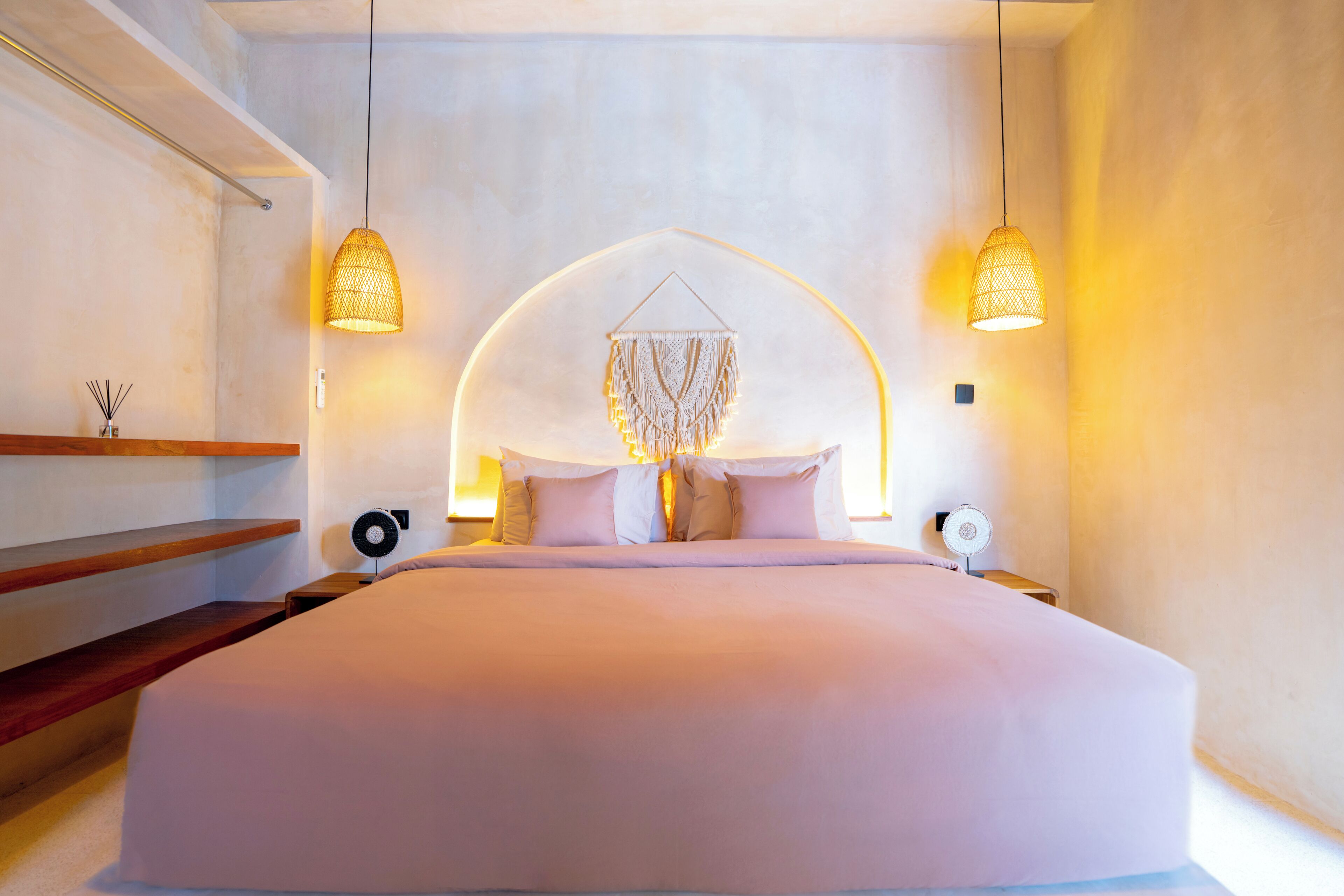 Un dormitorio moderno con una cama grande, dos lámparas de noche y una decoración de pared original.