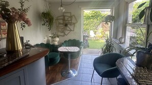 Una cocina con comedor, una planta colgante y vistas al jardín.