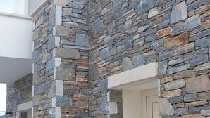 A building with a stone facade, a door, and a small porch area.