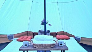 A tent with a table set up inside, featuring two white beds, a basket, two mugs, and a vase with flowers. - Secluded Mountaintop Retreat – Rustic Luxury & Panoramic Views at Freedom Farm (New Milford)