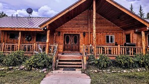 A wooden cabin with a prominent front porch, a satellite dish, and a metal roof. - Gilbert Creek Lodge, your Home Sweet Home in the Uinta's! (Mountain View)