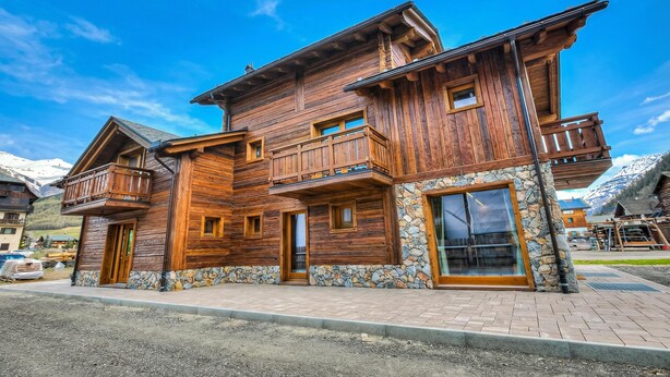 A wooden chalet with a stone foundation, wooden balconies, and large windows. - Belfiore, Livigno, Italy (Livigno)