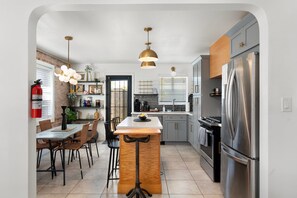A modern kitchen with a central island, stainless steel appliances, and pendant lighting.