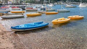 A harbor with numerous small boats docked along the shore, a clear sky, and buildings in the background. - Haldon View in Bishopsteignton (Teignmouth)