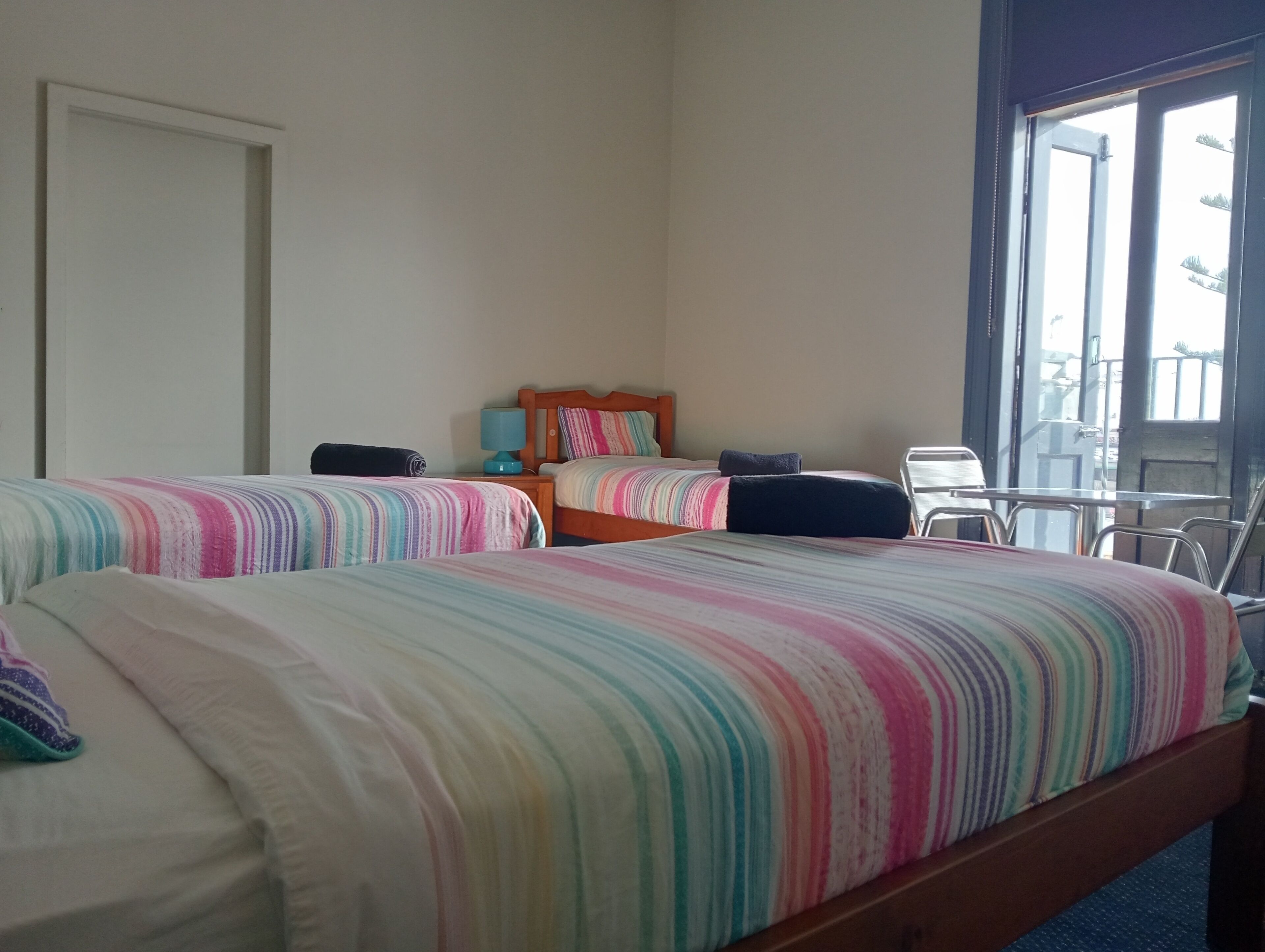 Ein Hotelzimmer mit zwei Betten, einem Nachttisch, einer Lampe und einem Sessel.