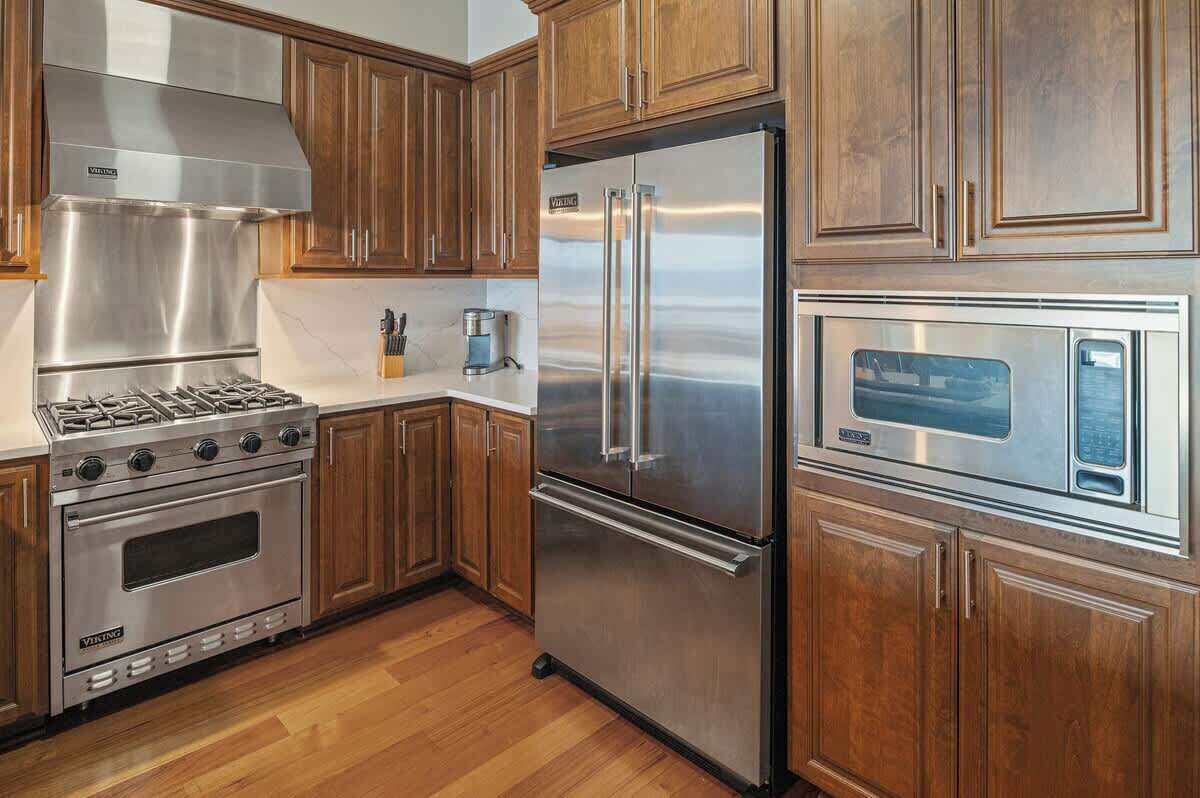 A kitchen with wooden cabinets, stainless steel appliances, and a built-in oven.