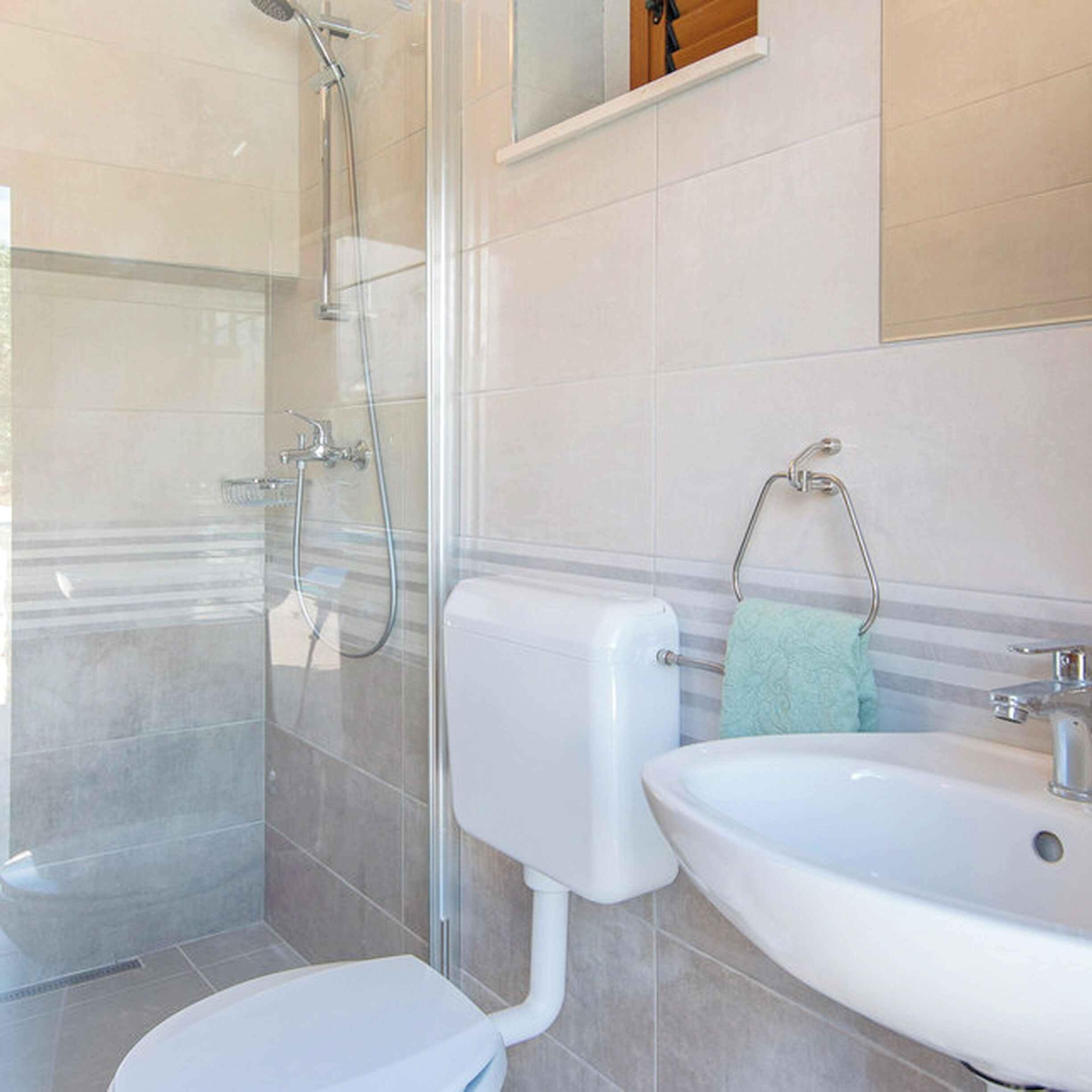 A bathroom with a shower, toilet, and sink.