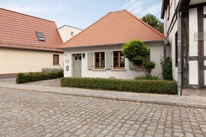 A traditional building with a tiled roof, a small window, and a door.