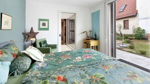 Een slaapkamer met een bed, een bureau, een stoel en uitzicht op buiten.