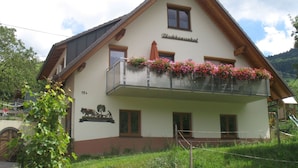 A two-story building with a balcony adorned with flowers, a sign reading 'Dischansental,' and a rustic wooden roof. - Apartment 'Dischhansenhof' with Mountain View, Shared Garden and Wi-Fi (Glottertal)