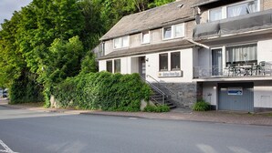 Un bâtiment à deux étages doté d’un balcon, d’une enseigne indiquant un restaurant et d’un escalier menant à l’entrée.
