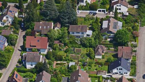 Vue aérienne d’un quartier résidentiel avec des maisons, des routes et de la végétation.