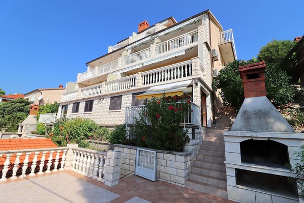 A two-story building with balconies, a stone facade, and a brick chimney. - Seaside Apartments Markota (Blato)