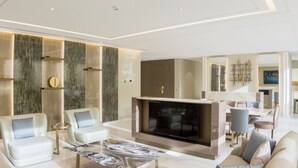 Una sala de estar moderna con un televisor de pantalla plana grande, asientos cómodos y una chimenea de mármol.