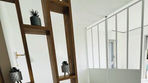 Een slaapkamer met een bed, een houten trap en een raam met zonwering.