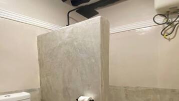 A bathroom with a toilet, a shower enclosure, and a towel rack.