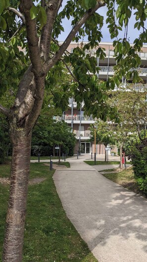 Stroll through lush gardens to a multi-level building with spacious balconies.