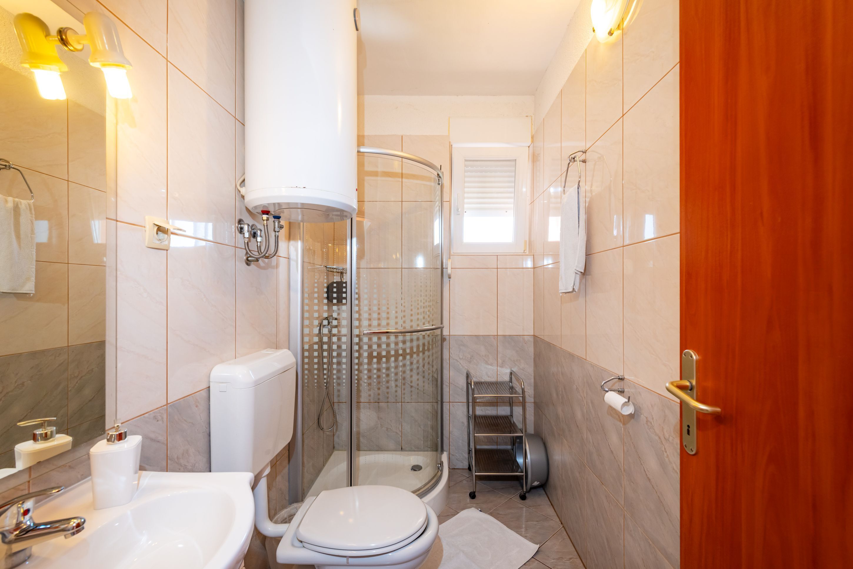 Een badkamer met toilet, wastafel, douche en handdoekrek.
