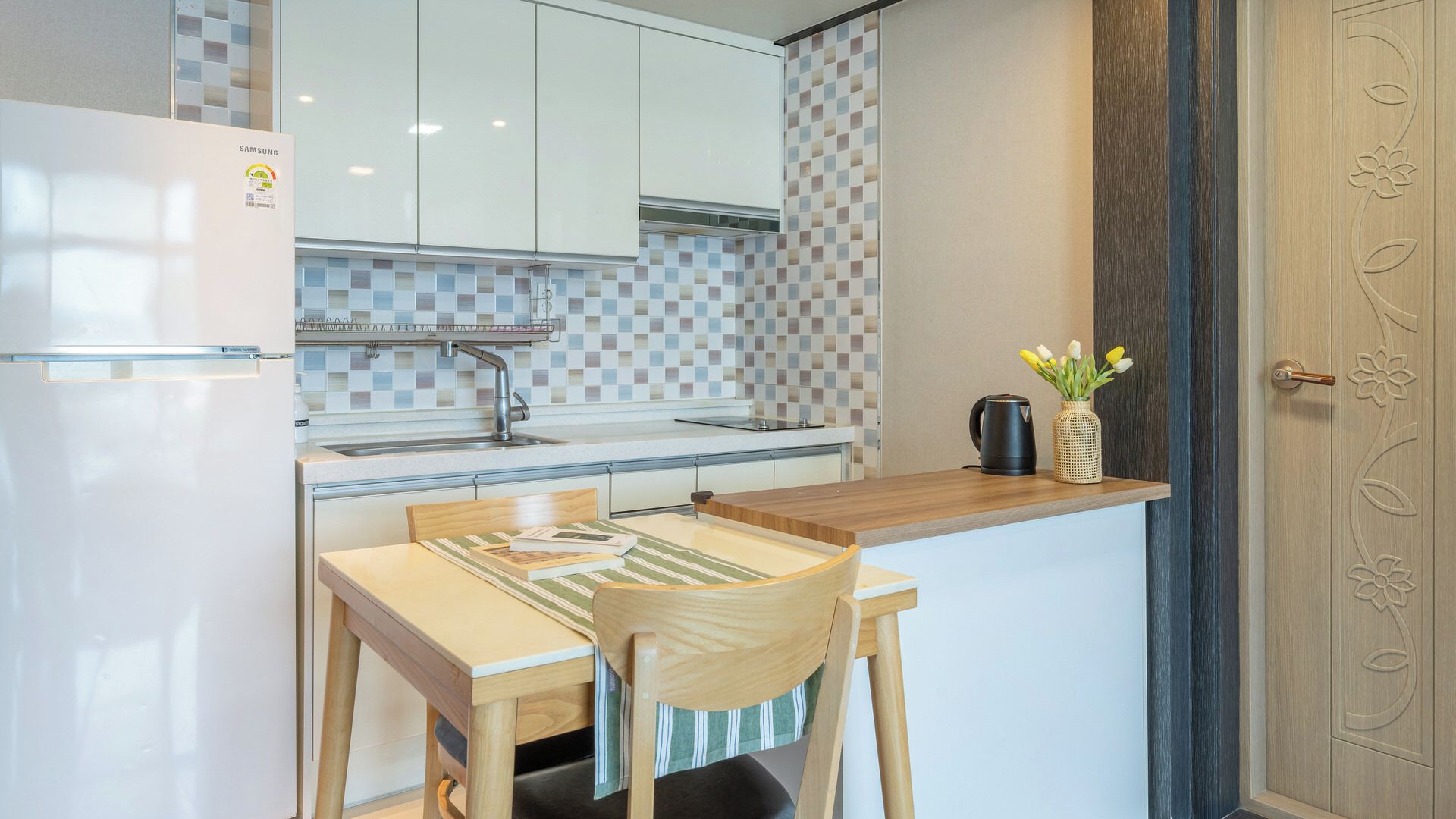 Una cocina moderna con un refrigerador blanco, un lavamanos y una encimera de madera.
