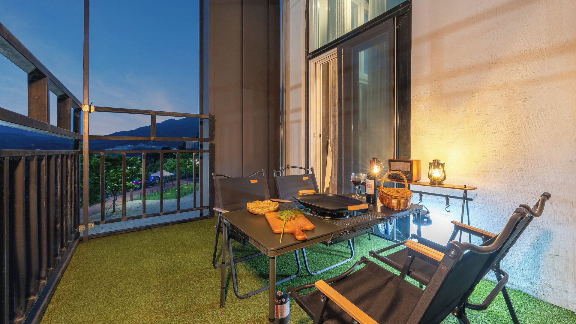 Ein Balkon mit Esstisch, Stühlen, einem Radio und einer Laterne.