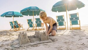 Una spiaggia con ombrelloni e lettini da spiaggia.