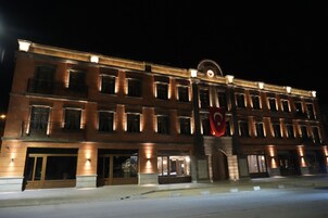 Un hotel de varios pisos con una entrada destacada, ventanas amplias y una bandera.