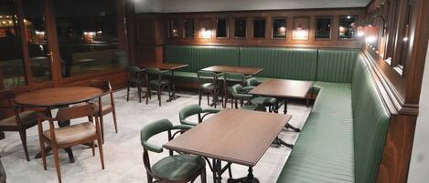 Un interior de restaurante con cabinas, mesas y sillas.