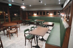 Un interior de restaurante con cabinas, mesas y sillas.