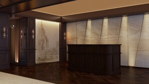 Un vestíbulo moderno con paneles de madera oscura, una pared de mármol con diseño de paisaje urbano y un mostrador de recepción central de madera oscura.