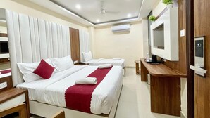 Une chambre d’hôtel avec deux lits, une télévision, un bureau et un appareil de climatisation.