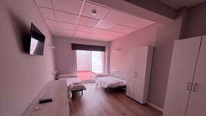 A room with two beds, a desk, and a wardrobe. - Unicorn Residence for Students (Valencia)