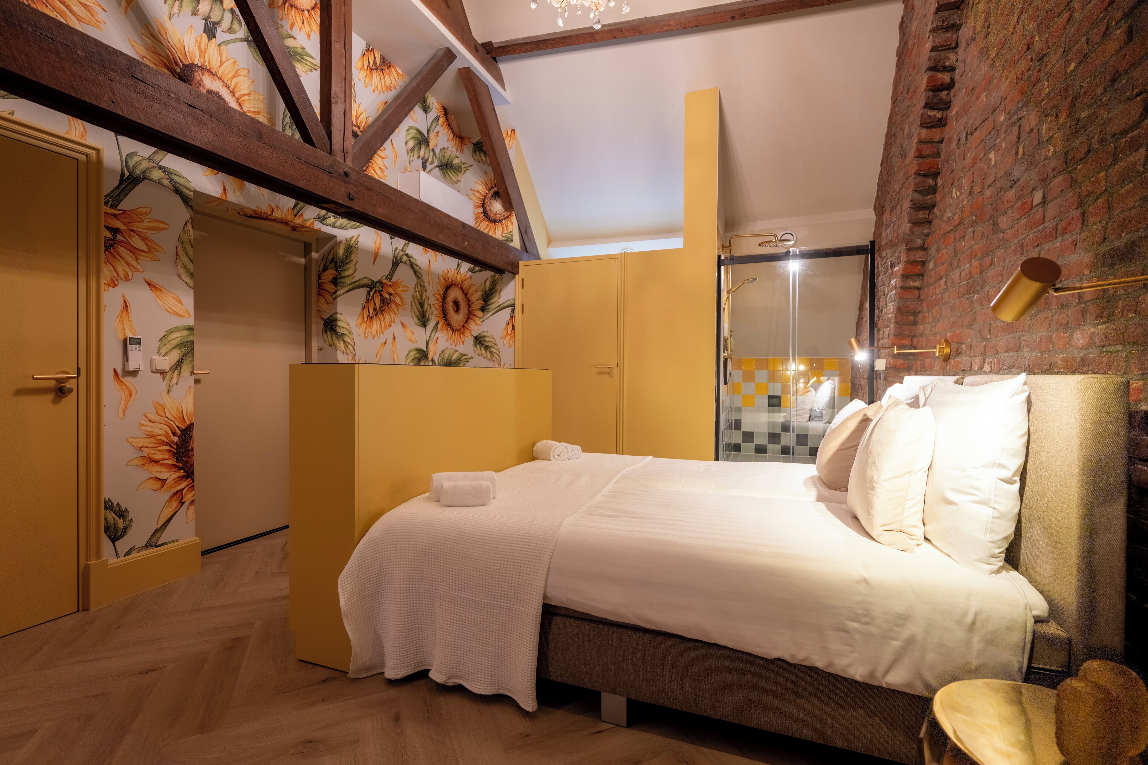 Ein Schlafzimmer mit Bett, Kleiderschrank, Spiegel und einer Ziegelwand.