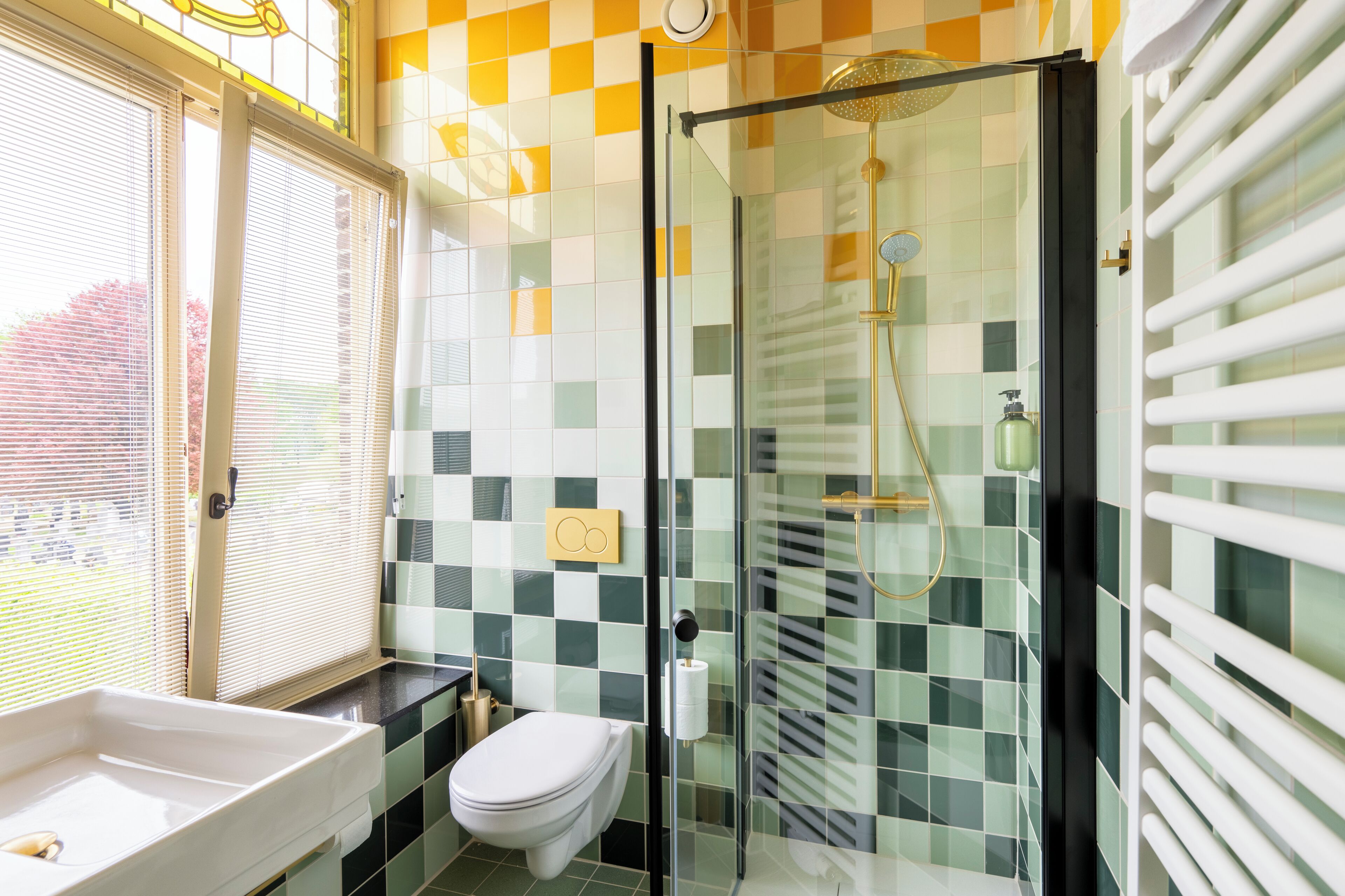 A bathroom with a glass shower enclosure, a white sink, and a toilet.