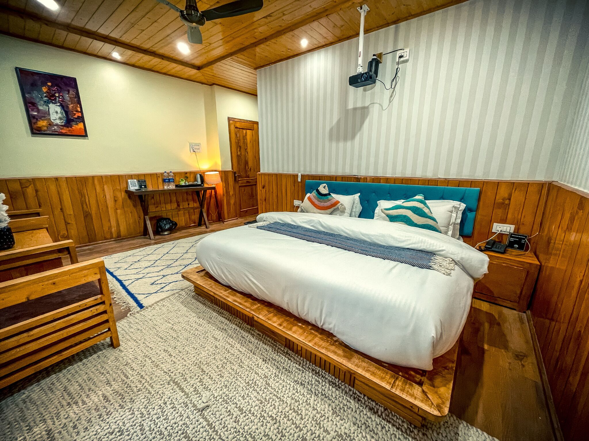A spacious bedroom with a large bed, wooden headboard, and a ceiling fan.