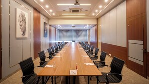 A conference room with a long table, black chairs, and a projector.