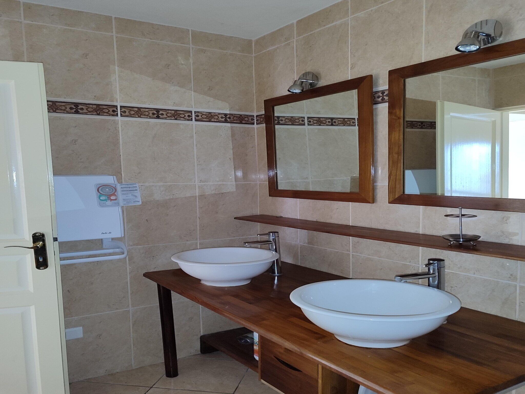 A bathroom with two sinks, a mirror, and a towel rack.