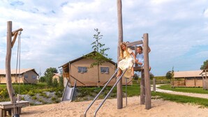 Un parque infantil con columpios, tobogán y estructura para escalar.