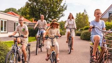 A group of people riding bicycles on a paved path.