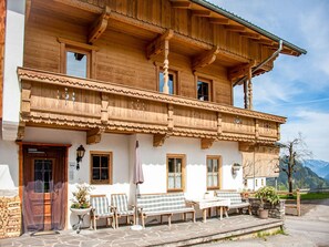 A traditional wooden chalet with a balcony, stone steps, and outdoor seating. - Apartment in Hainzenberg in a ski area (Hainzenberg)