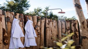 Une clôture en bois avec deux serviettes blanches suspendues à des crochets.
