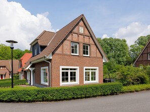 A two-story house with a pitched roof, brick exterior, and white-framed windows.