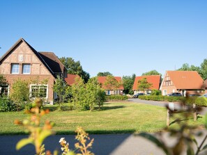 Ein Wohngebiet mit Ziegelhäusern, blauem Himmel und gepflegtem Rasen.