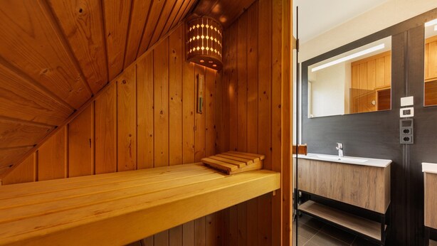 A sauna room with wooden walls and a bench. - Home w/ Sauna & Garden (Bad Bentheim)
