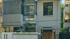 En toetages bolig med balkon, hegnet indgang og en lille have.