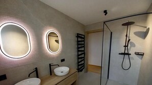 A modern bathroom with two sinks, a shower, and a mirror with integrated lighting. - Deluxe One-Bedroom Apartment with Lake View (Sankt Wolfgang im Salzkammergut)